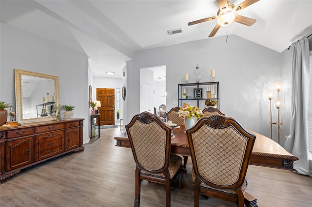 dining space with lofted ceiling, visible vents, a ceiling fan, and light wood-style flooring