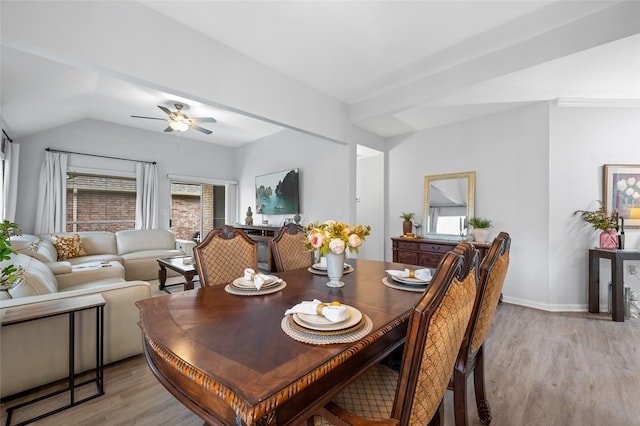 dining area featuring baseboards, a ceiling fan, vaulted ceiling, and light wood-style floors