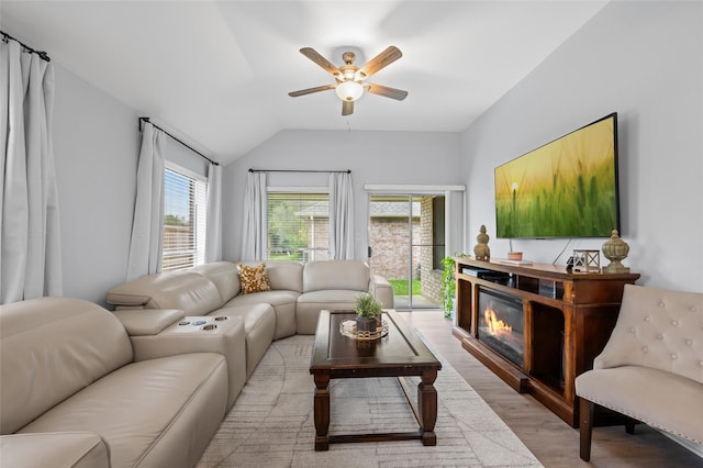 living room featuring light wood-style flooring, a wealth of natural light, ceiling fan, and lofted ceiling