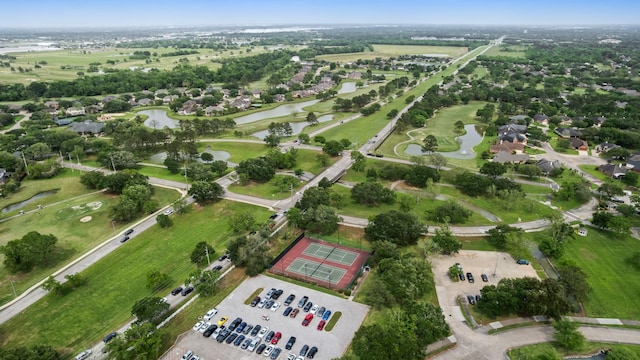 drone / aerial view with view of golf course and a water view