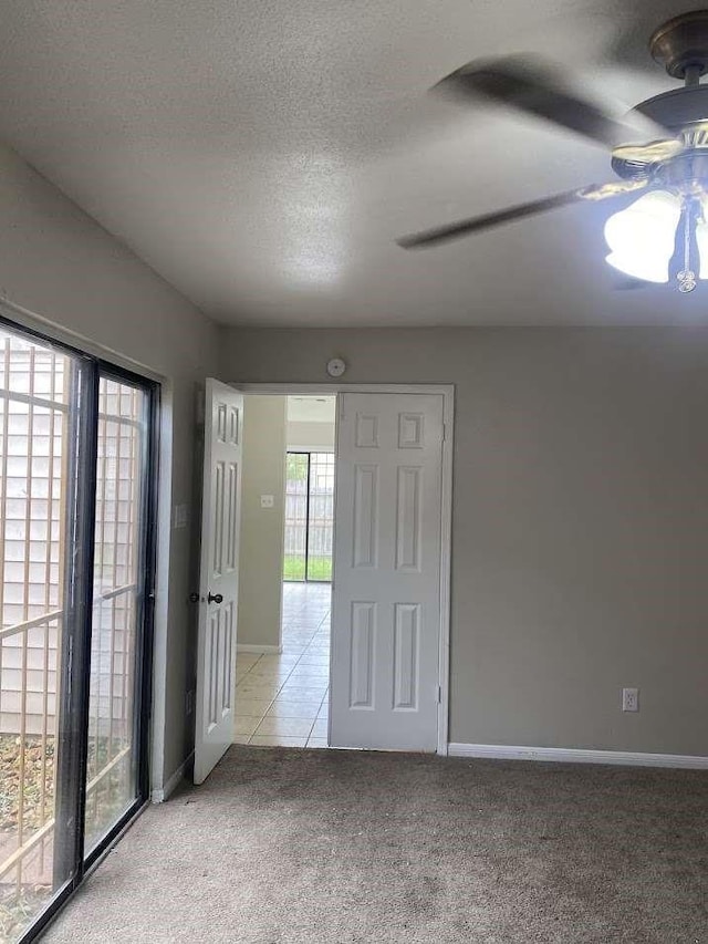 12403 Seaswept Dr, Houston, TX 77071 - carpeted spare room with a textured ceiling, baseboards, a ceiling fan, and tile patterned floors