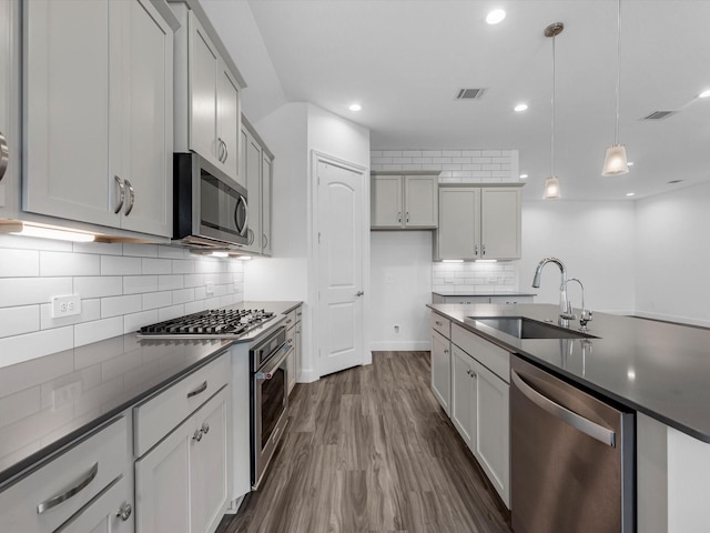 kitchen with a sink, visible vents, dark countertops, and stainless steel appliances