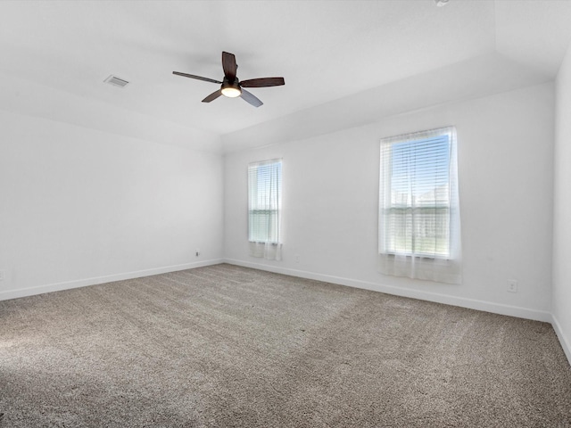 carpeted spare room featuring baseboards, a ceiling fan, and visible vents