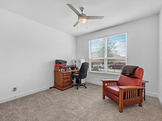 office space featuring baseboards, a ceiling fan, and light colored carpet