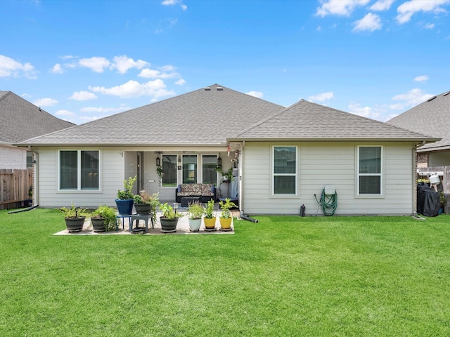 back of house featuring a yard, fence, a patio, and roof with shingles