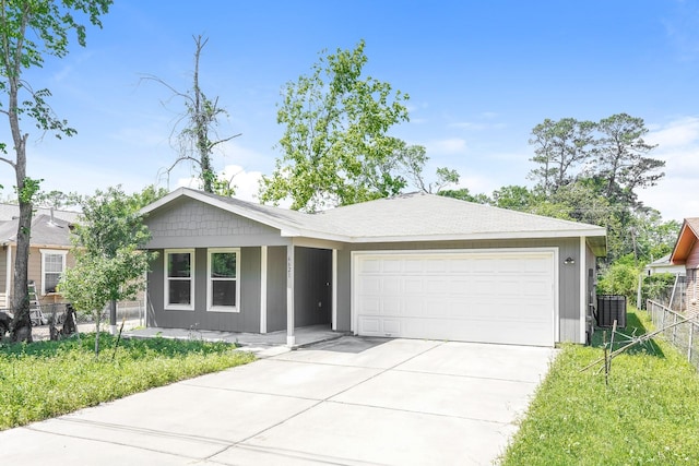 ranch-style home featuring an attached garage, cooling unit, driveway, and fence