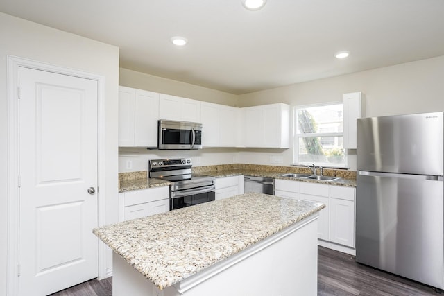 kitchen featuring dark wood-style flooring, white cabinetry, a sink, and appliances with stainless steel finishes