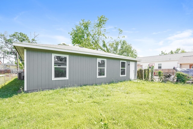 rear view of property featuring fence and a lawn