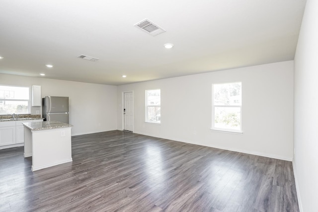 unfurnished living room featuring recessed lighting, visible vents, a sink, and dark wood finished floors
