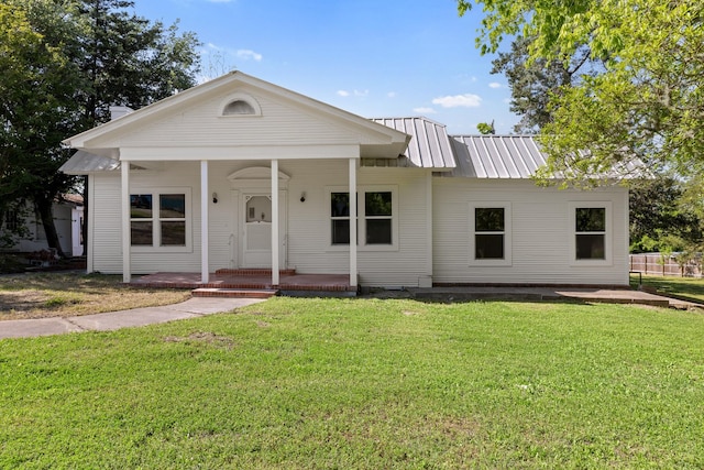 view of front of home featuring a porch, metal roof, and a front yard