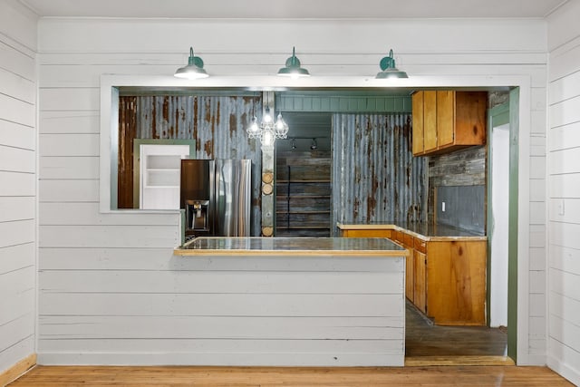 bar featuring stainless steel fridge and wood finished floors