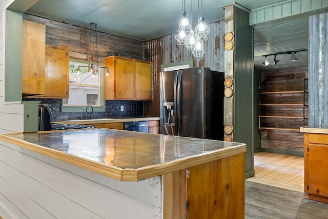 kitchen featuring stainless steel fridge with ice dispenser, a peninsula, dark wood-style floors, brown cabinetry, and a sink