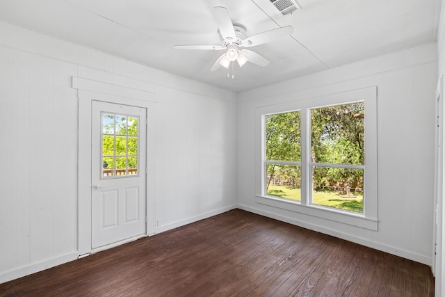 spare room featuring visible vents, a wealth of natural light, ceiling fan, and dark wood-style floors