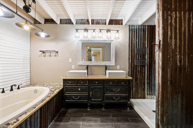 bathroom featuring double vanity, a garden tub, beamed ceiling, and a sink