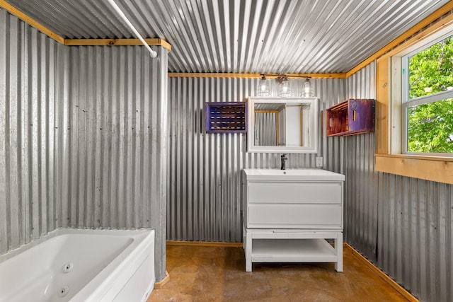 bathroom featuring concrete floors, vanity, and a whirlpool tub