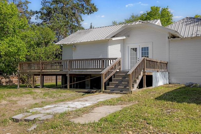 back of house featuring stairway, metal roof, and a wooden deck