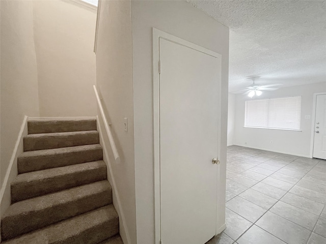 12023 Greenwood Forest Dr Unit B, Houston, TX 77066 - stairway featuring a textured ceiling, baseboards, a ceiling fan, and tile patterned flooring