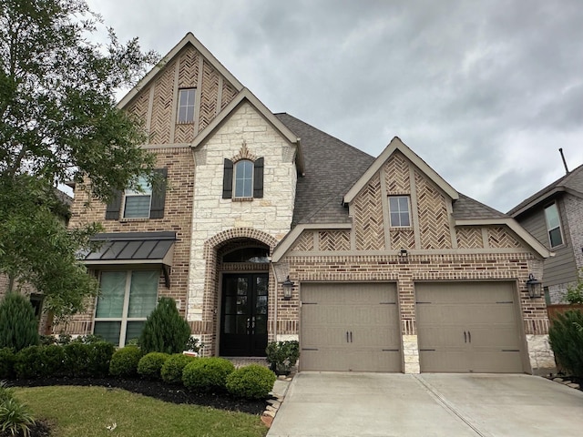 view of front of property with brick siding, an attached garage, stone siding, and concrete driveway