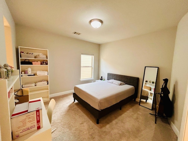 bedroom featuring visible vents, light colored carpet, and baseboards