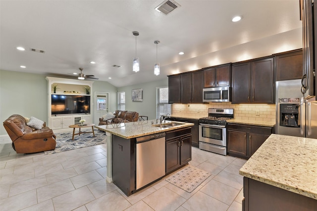 kitchen featuring dark brown cabinets, a sink, open floor plan, appliances with stainless steel finishes, and visible vents