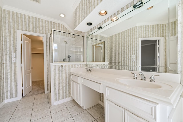 bathroom with a shower stall, crown molding, a sink, and wallpapered walls