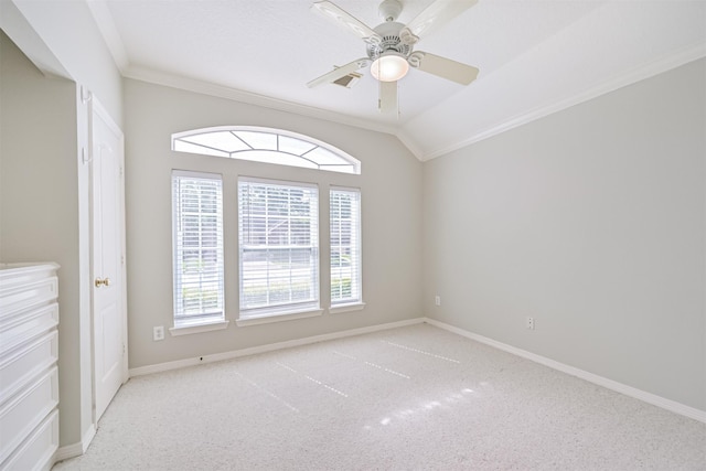 carpeted empty room featuring lofted ceiling, visible vents, crown molding, baseboards, and ceiling fan