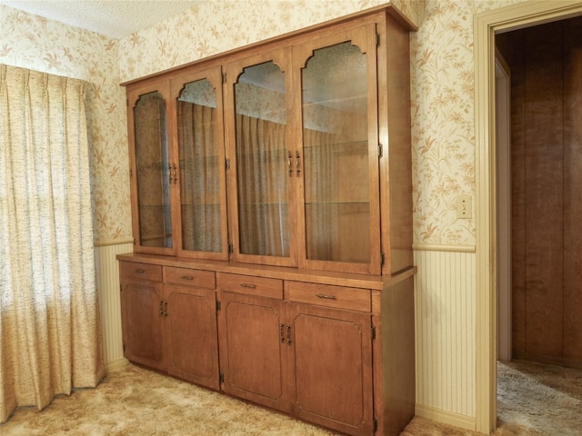 room details with a wainscoted wall, carpet, and wallpapered walls