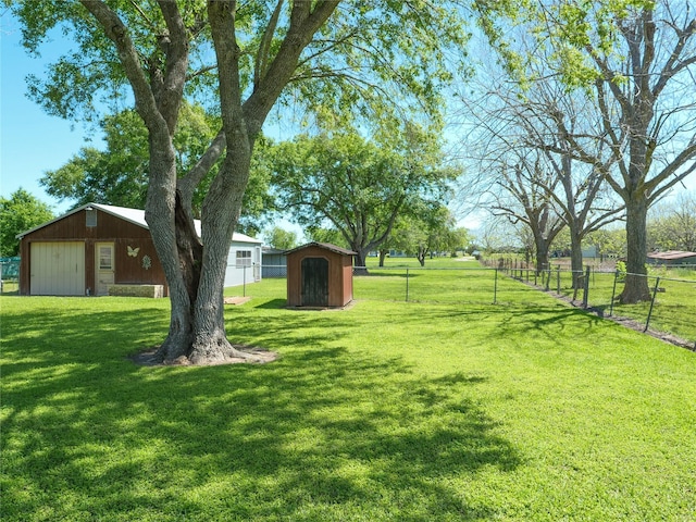 view of yard with fence, an outdoor structure, and a shed