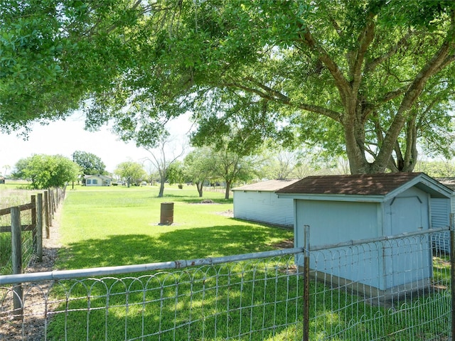view of yard with an outbuilding, a fenced backyard, and a storage unit