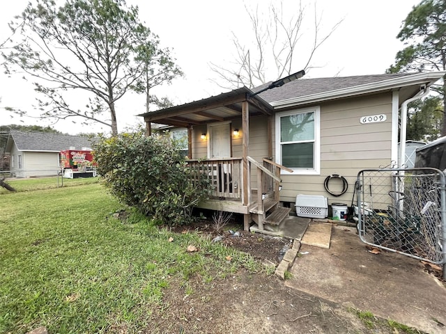 exterior space featuring a yard, fence, and roof with shingles