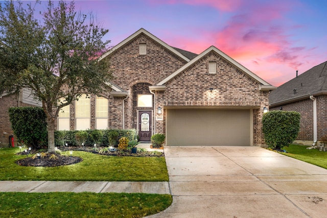 view of front facade featuring a front yard, brick siding, driveway, and an attached garage