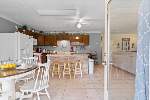 kitchen featuring crown molding, ceiling fan, light tile patterned floors, white appliances, and light countertops