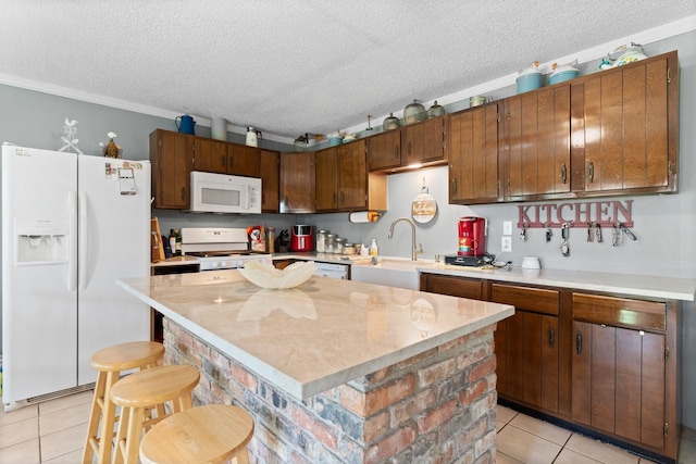 kitchen featuring white appliances, light tile patterned floors, light countertops, a textured ceiling, and a sink