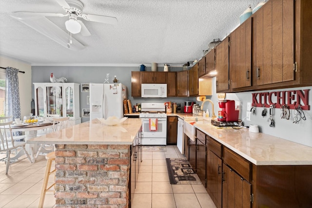 kitchen featuring light tile patterned floors, light countertops, ceiling fan, white appliances, and a textured ceiling
