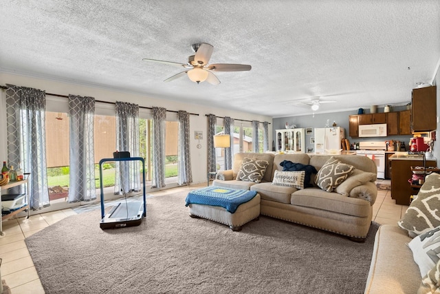 living area with light tile patterned floors, ceiling fan, and a textured ceiling