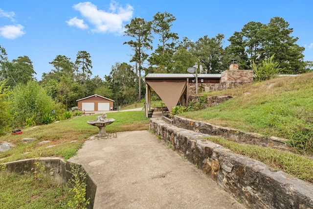view of yard featuring a detached garage and an outdoor structure
