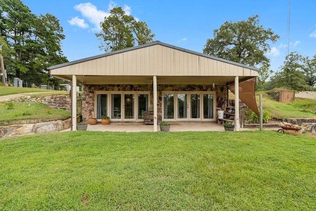 back of property featuring a yard, a patio, french doors, and stone siding