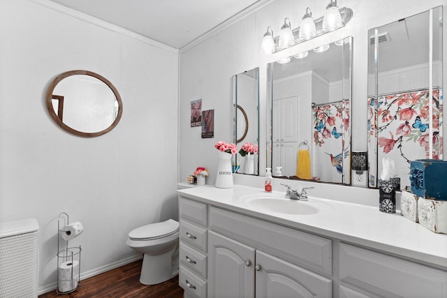 bathroom with vanity, baseboards, ornamental molding, toilet, and wood finished floors