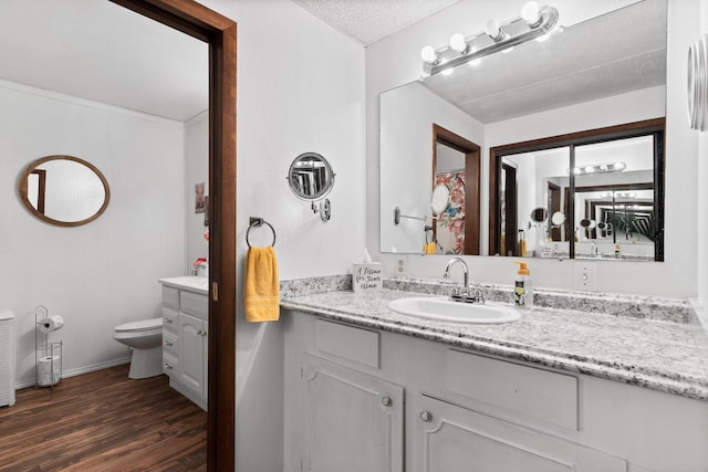 bathroom featuring vanity, baseboards, toilet, and wood finished floors