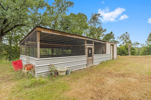 view of property exterior featuring exterior structure, an outdoor structure, and a lawn