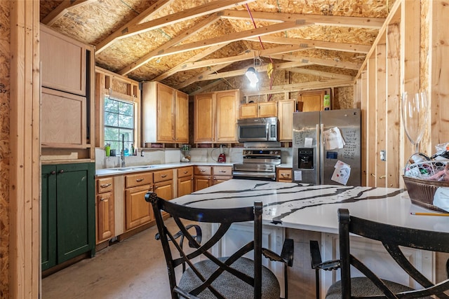 kitchen with a sink, light countertops, appliances with stainless steel finishes, concrete flooring, and lofted ceiling