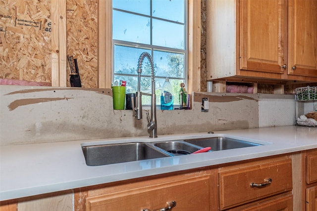 kitchen featuring light countertops, a sink, and backsplash