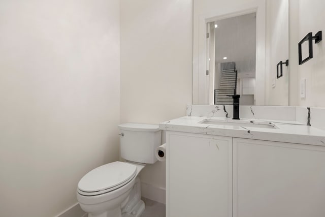 bathroom featuring baseboards, toilet, and vanity