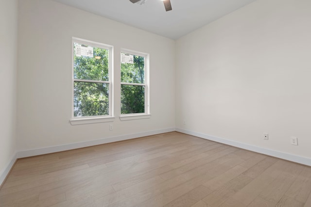 empty room with baseboards, light wood-type flooring, and ceiling fan