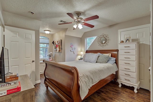 bedroom with dark wood-style flooring, visible vents, a ceiling fan, and a textured ceiling