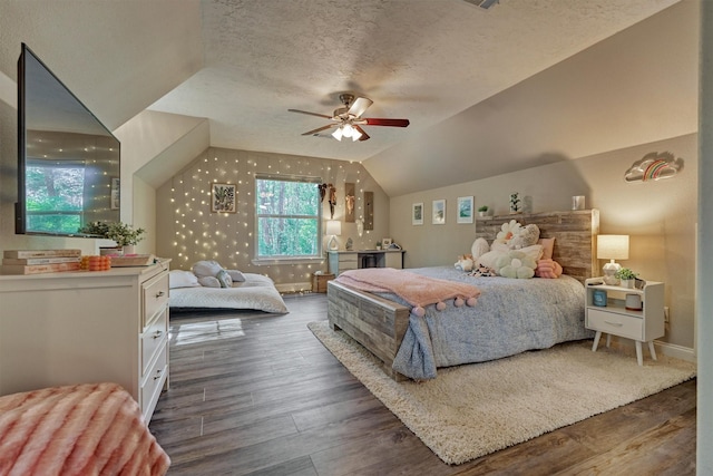 bedroom with a textured ceiling, a ceiling fan, vaulted ceiling, wood finished floors, and baseboards