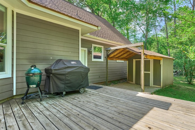 deck featuring a shed, an outbuilding, and area for grilling