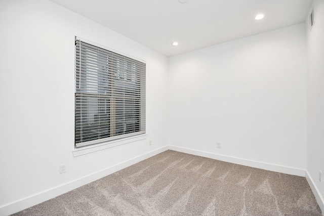 carpeted empty room featuring recessed lighting, visible vents, and baseboards