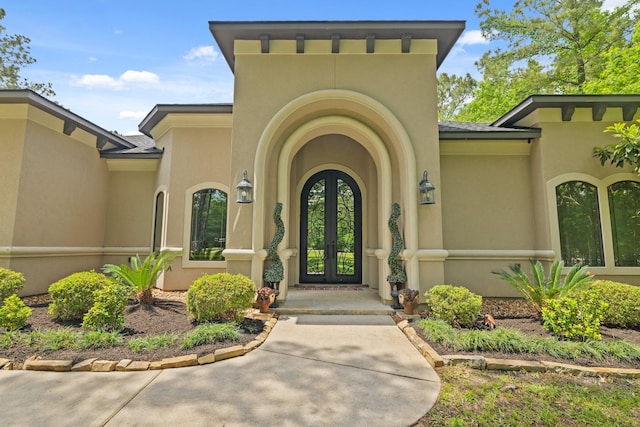 property entrance featuring stucco siding and french doors