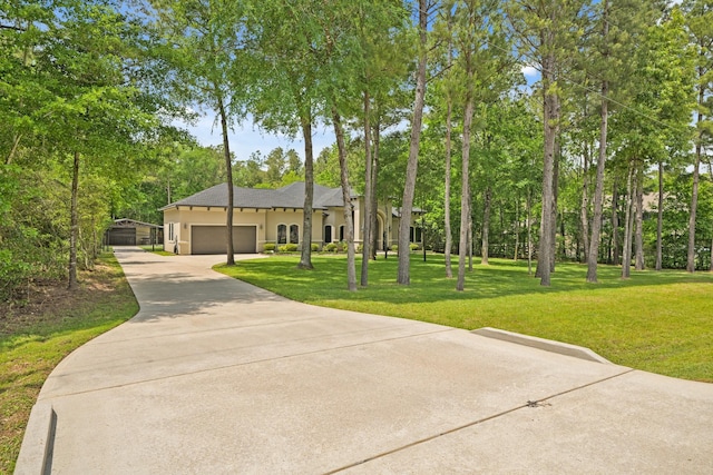 view of front of property featuring an attached garage, concrete driveway, a front lawn, and stucco siding
